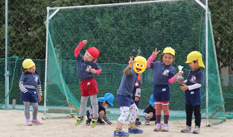 ثلاثة أطفال من الأسود يلعبون كرة القدم في كوماموتو